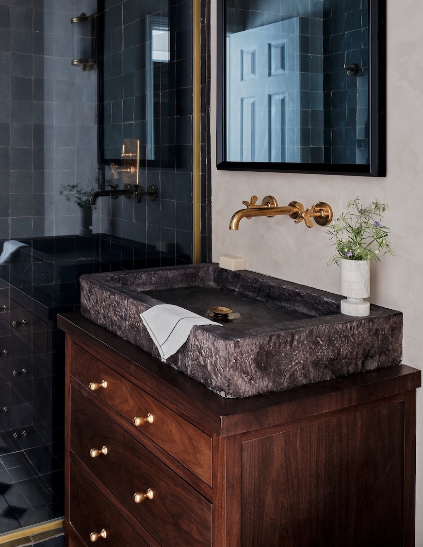 a moody bathroom with dark wood and tile