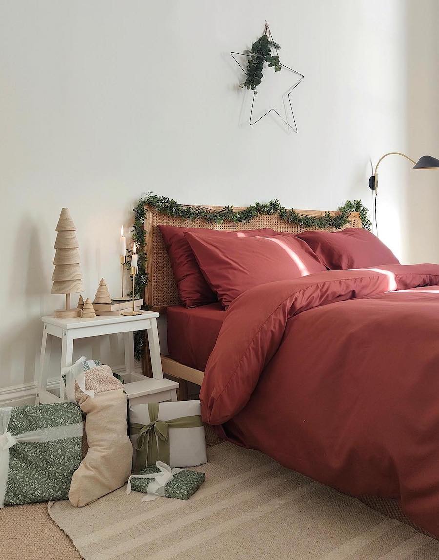 a bedroom with red bedding and earthy holiday decor