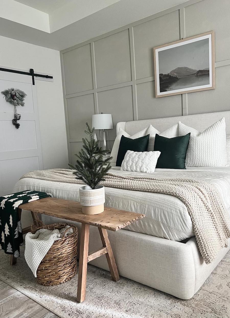 a neutral bedroom with green accents and pine tree decor