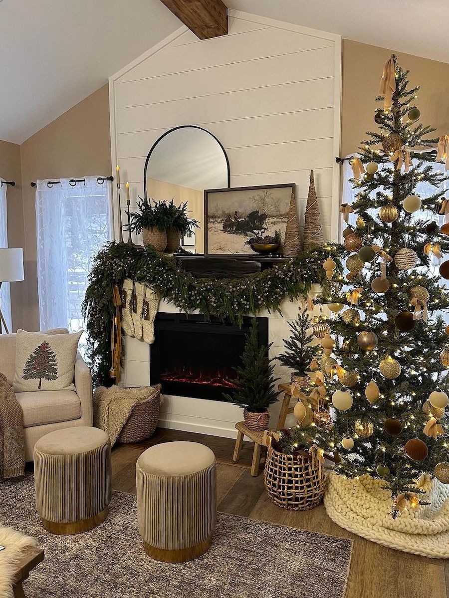 a white mantle with lit pine garland, vintage art, rustic trees, and stockings