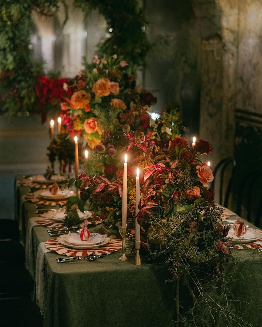 christmas table decorations featuring large florals, red and green hues, and peppermint swirl accents