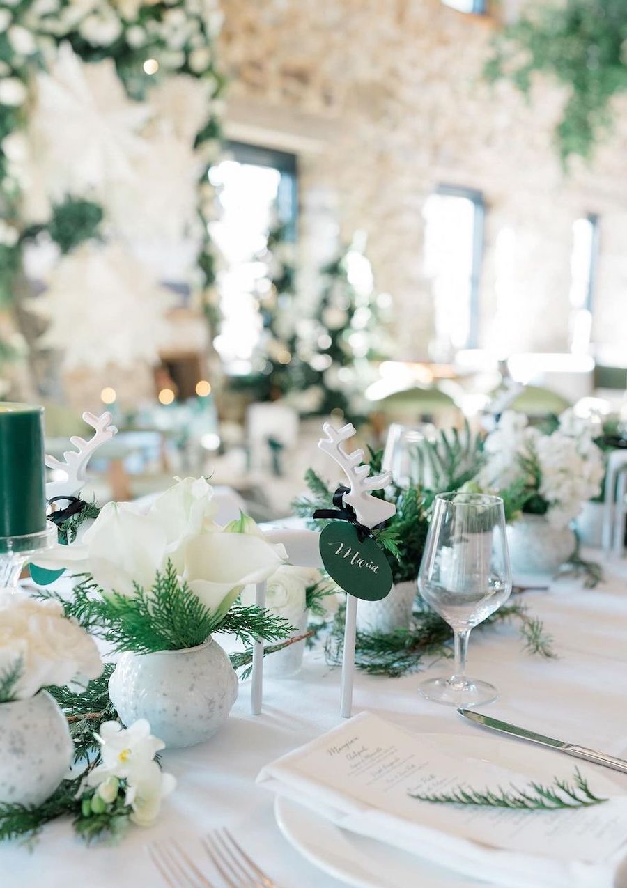 christmas table decorations featuring ivory and green tones with lilies and reindeer accents