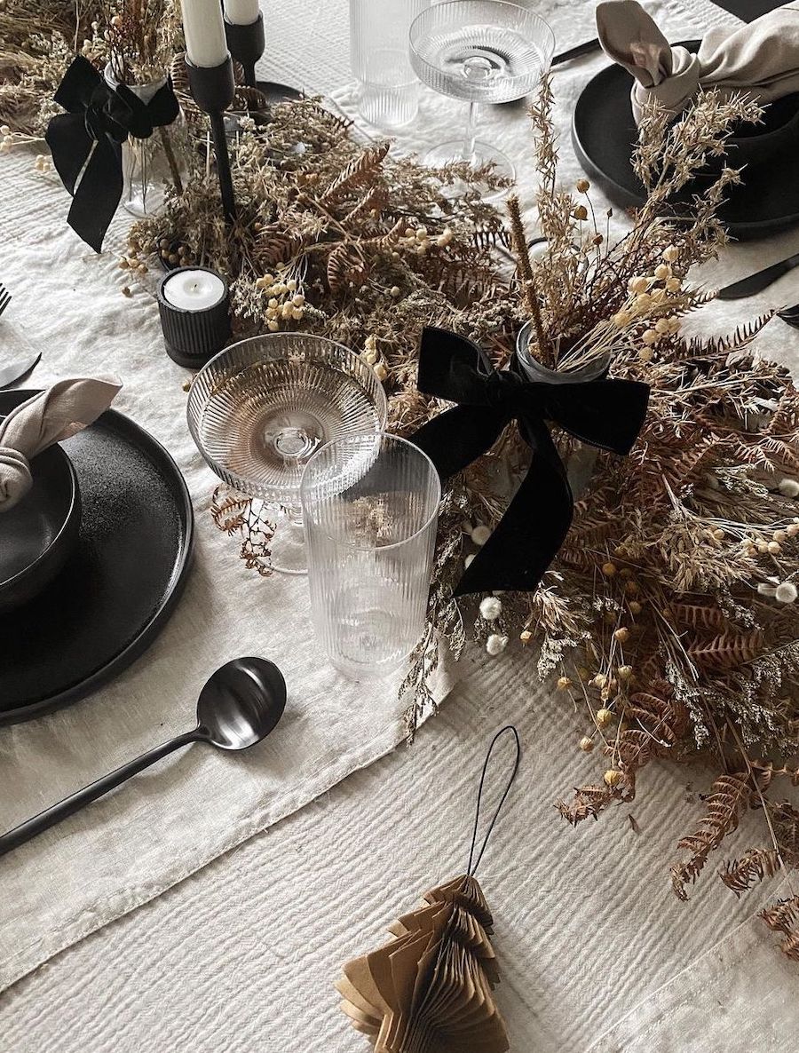christmas table decorations featuring dried florals and black decor
