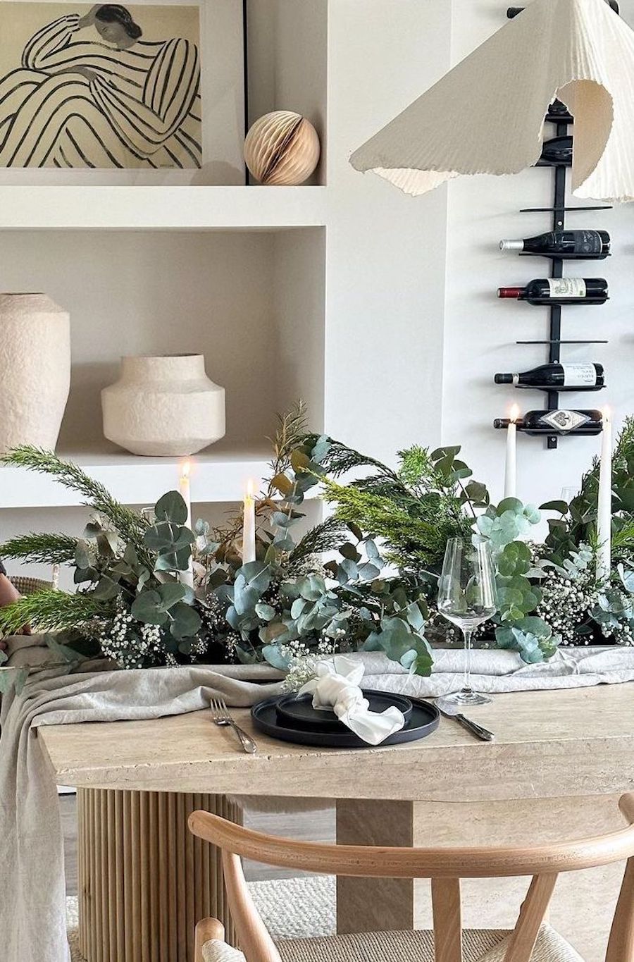 christmas table decorations featuring eucalyptus, pine, baby's breath, and white ribbons