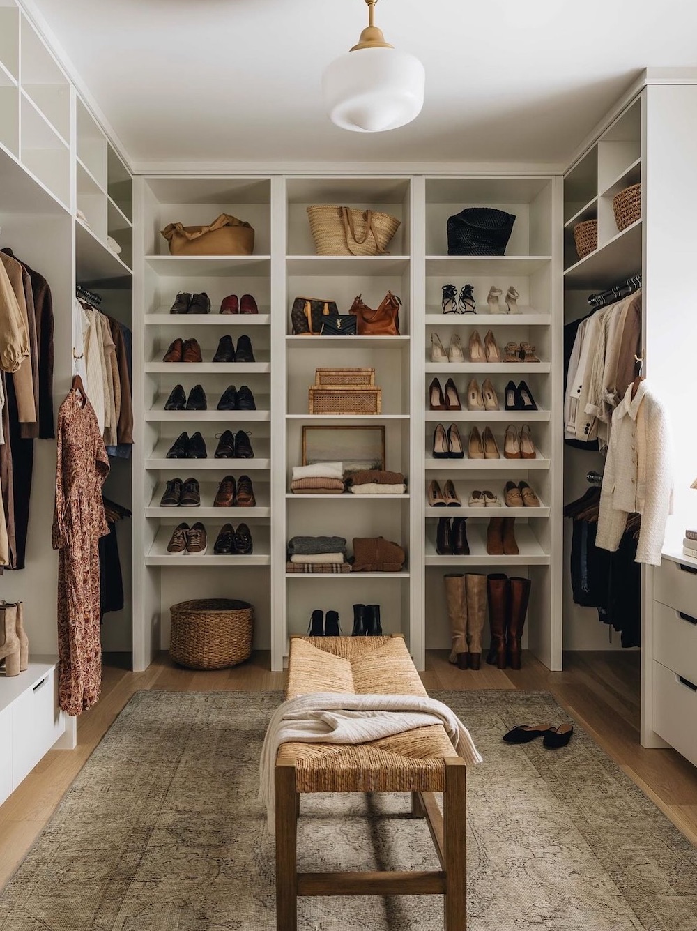 a walk in closet with built in shelves and shoe display