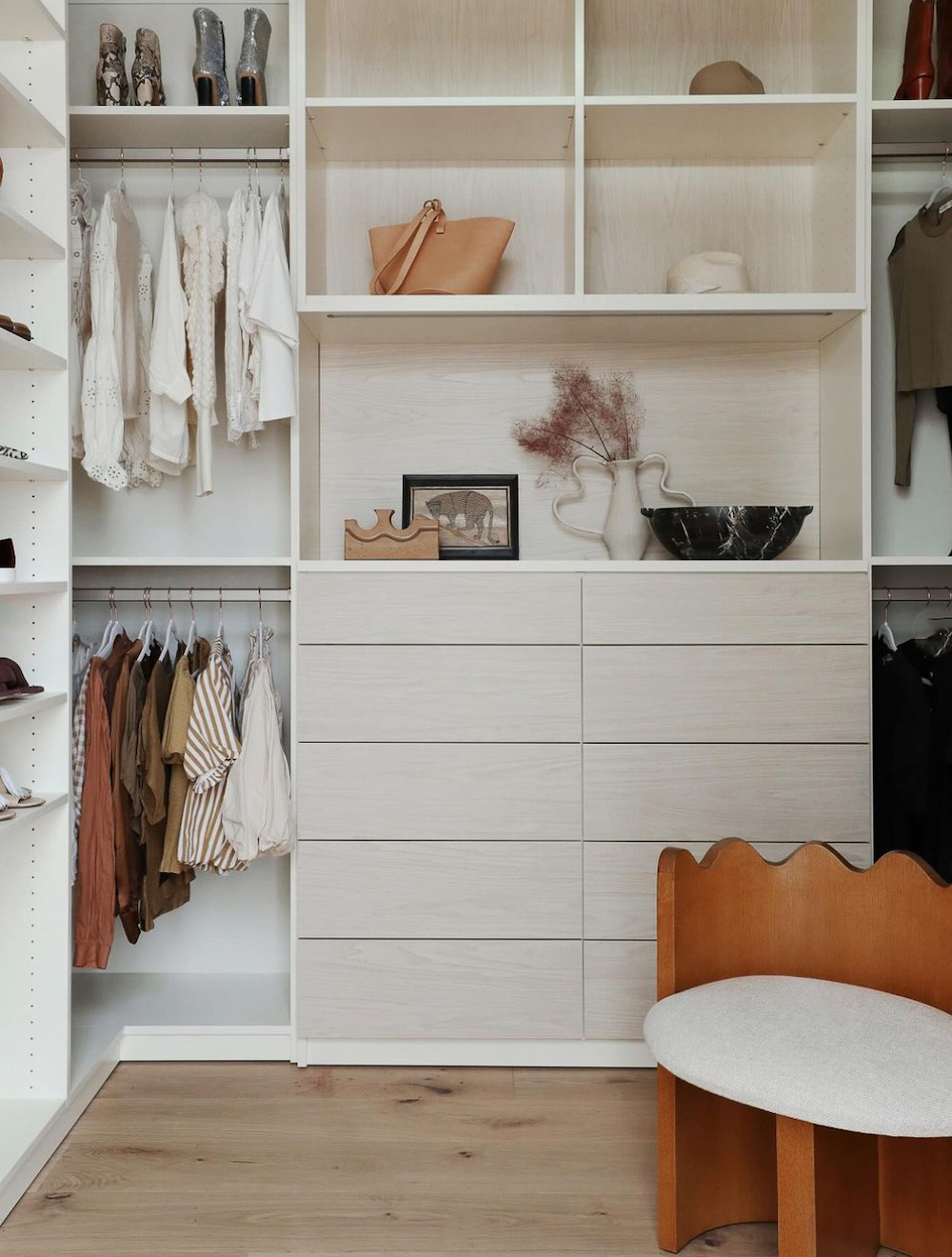 a walk in closet with drawers, shelves, and hanging rods