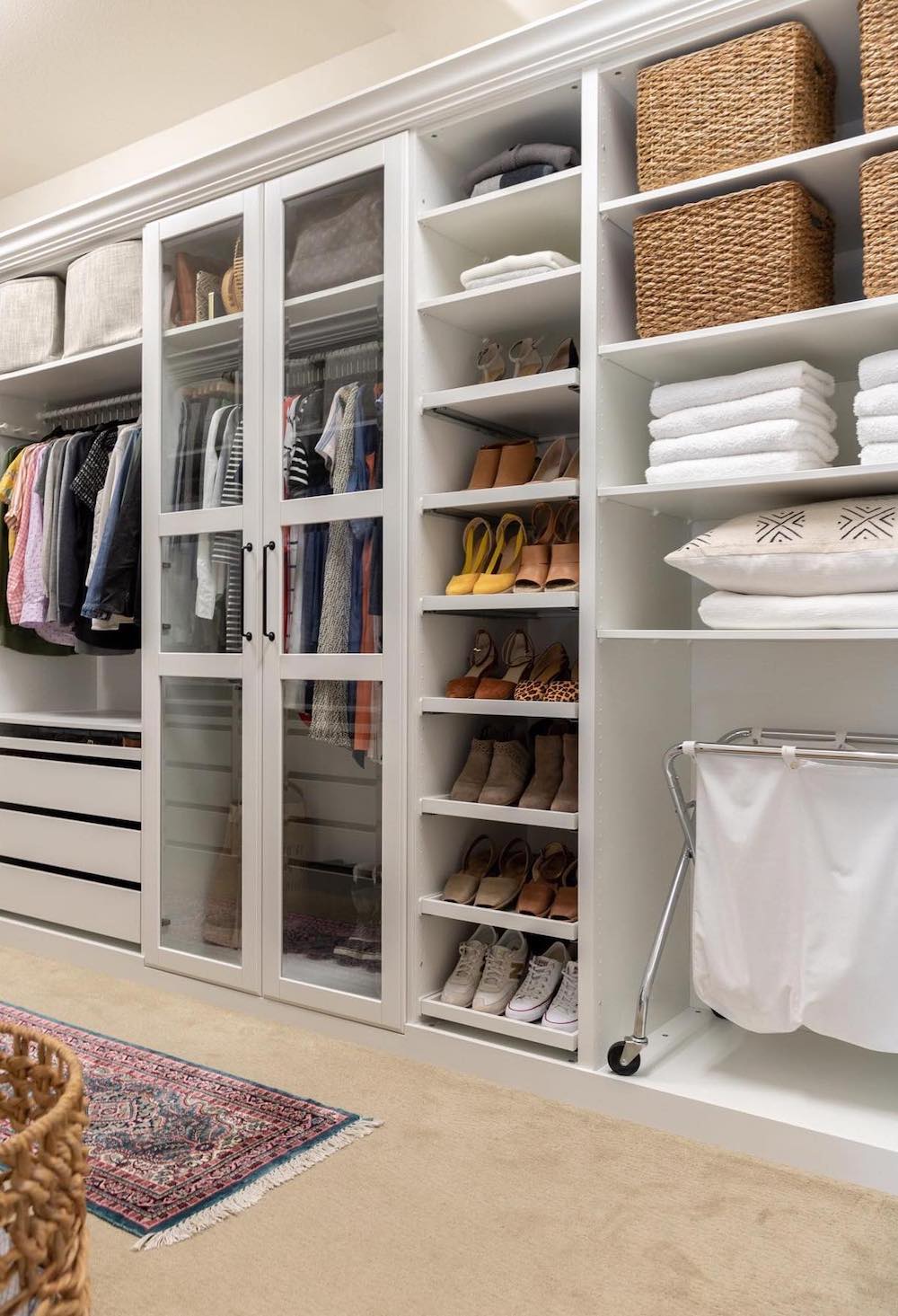 a walk in closet with built in shelves and cabinets