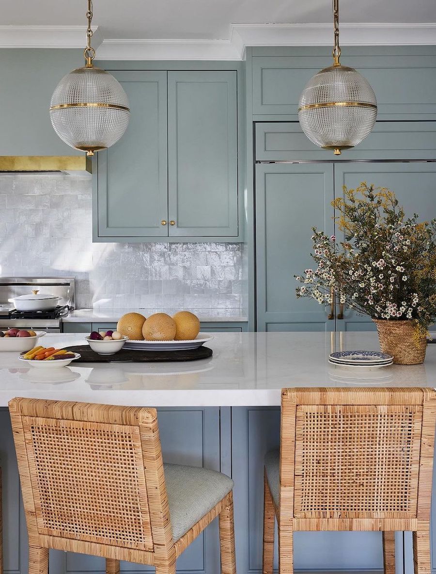 a kitchen with rattan chairs and blue cabinets