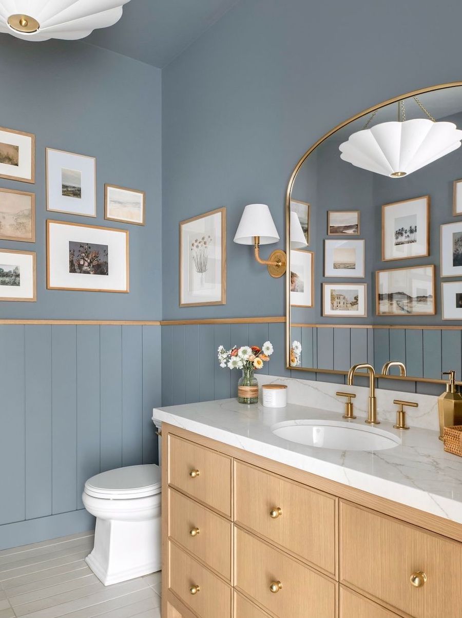 a bathroom with blue walls and coastal decor