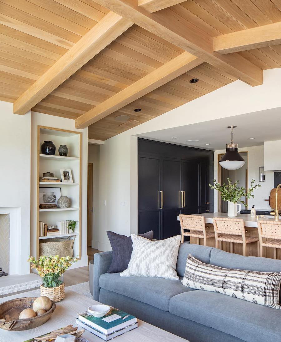 a coastal themed living room with a blue couch and vaulted ceilings