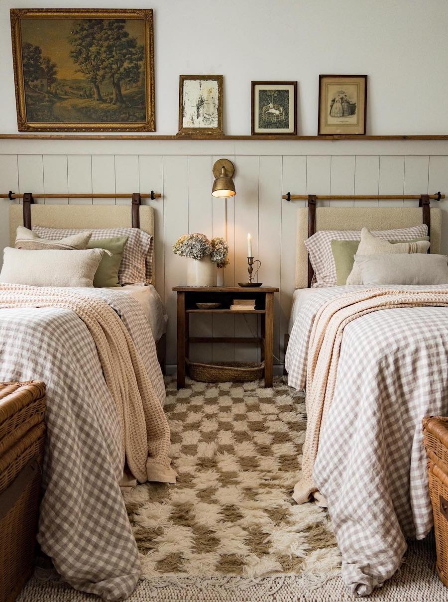 a cottagecore bedroom with checkerboard and plaid details and vintage wall art