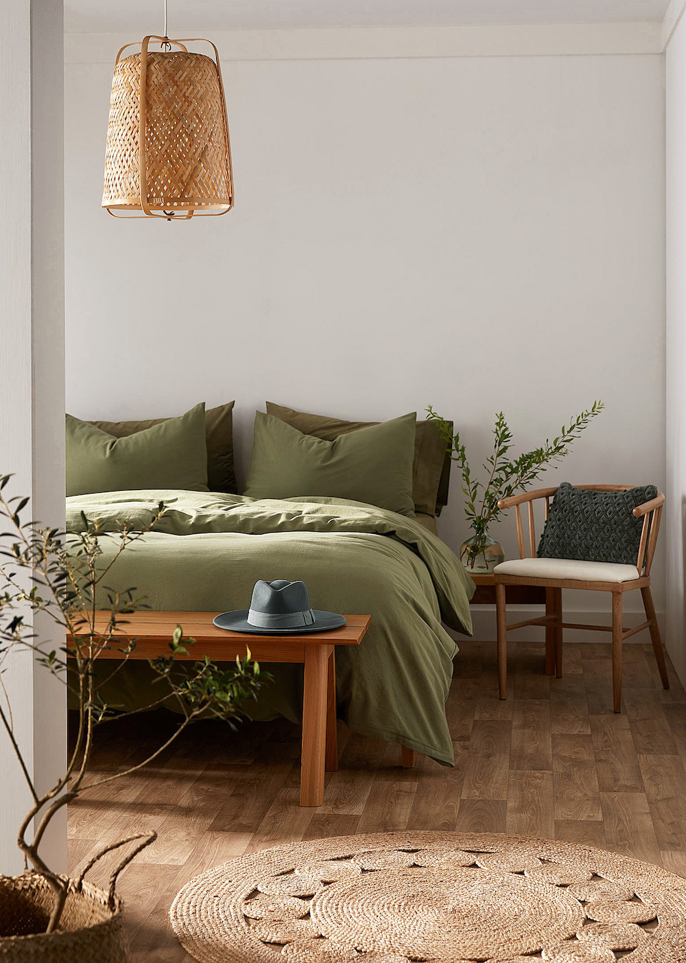 an earthy bedroom with green bedding, houseplants, and boho decor