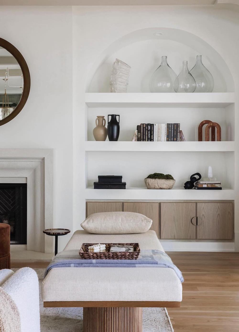 a bright ivory room featuring built-in shelves next to the fireplace