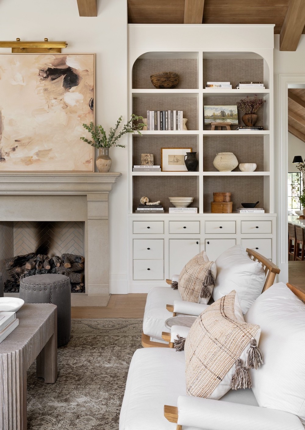a bright and modern room featuring built-in shelves and drawers next to the fireplace