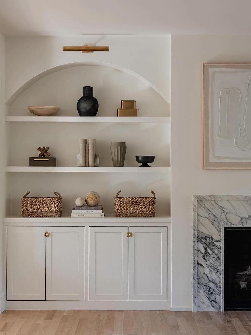 a modern neutral room featuring built-in shelves next to the fireplace