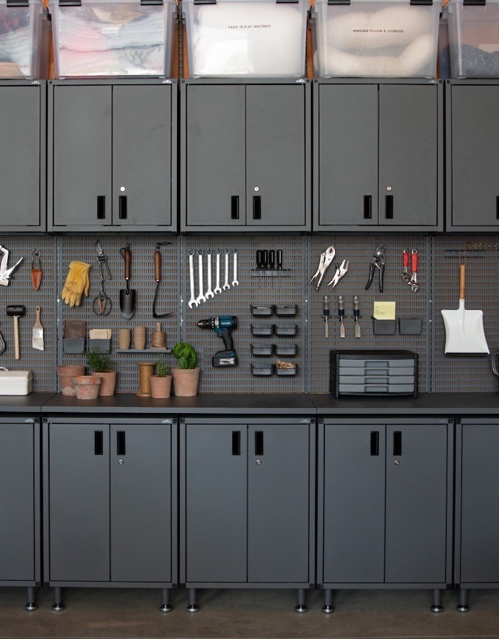 an organized garage featuring built in cabinets
