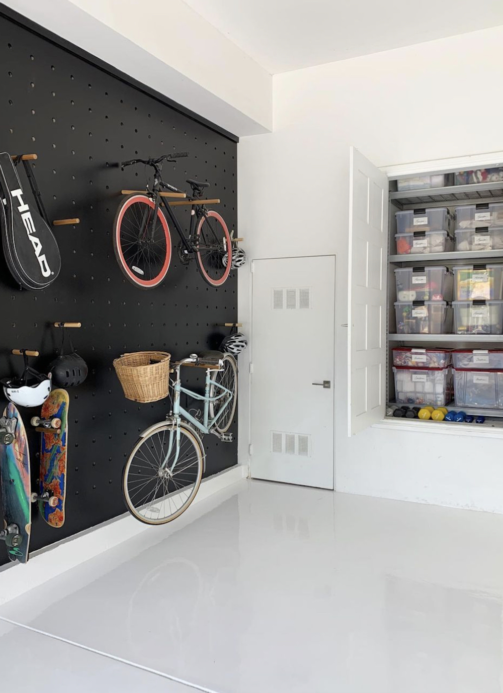 an organized garage featuring a peg wall and cabinet