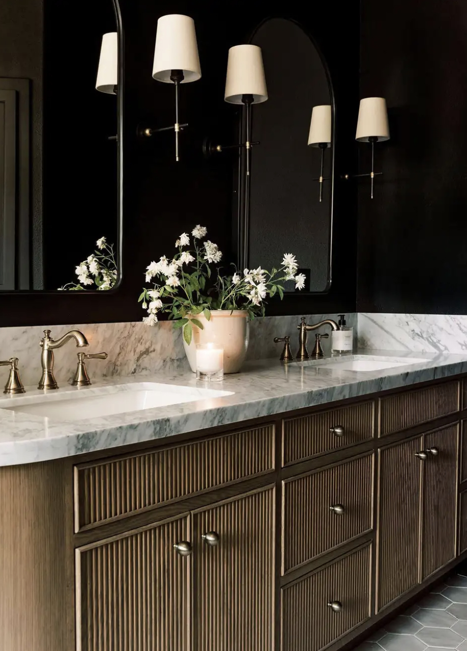 a bathroom with marble counters and black walls