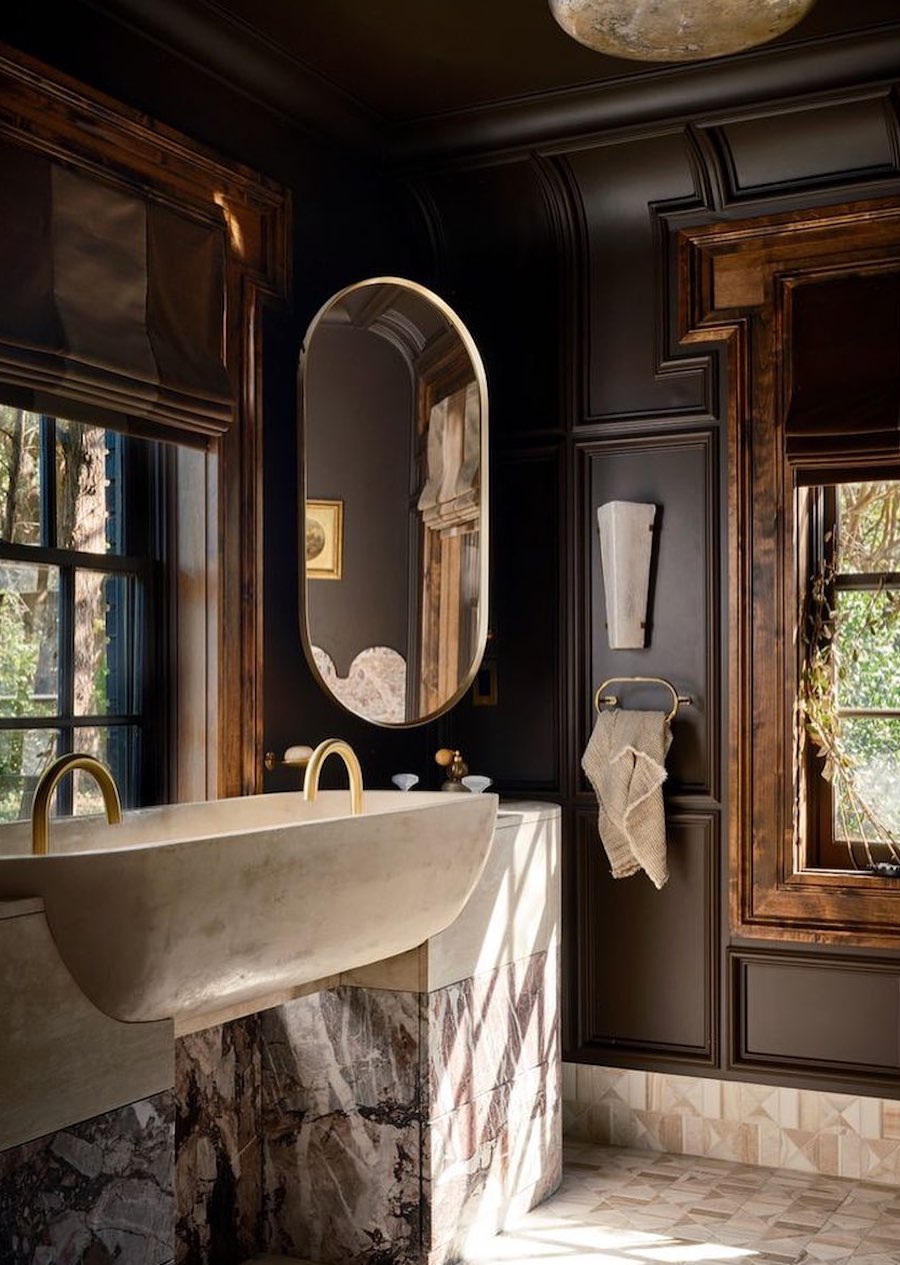 a bathroom with dark wood tones and black walls