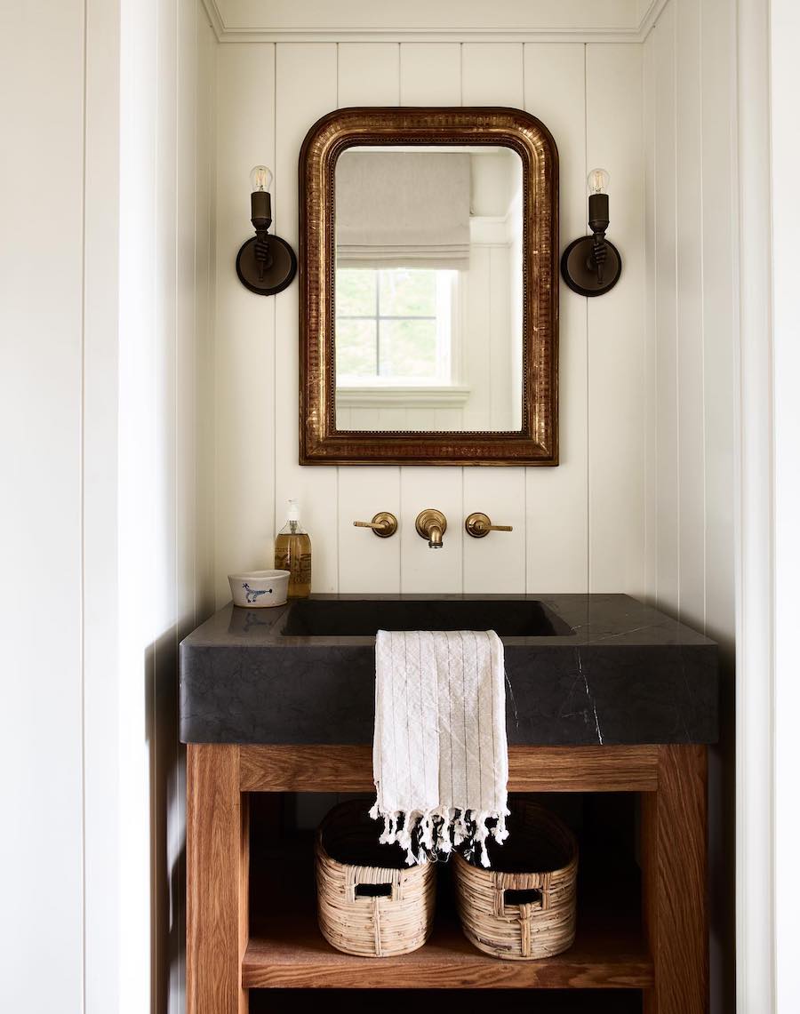 a bathroom sink with moody tones and antique decor