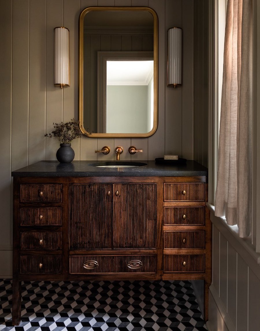 a bathroom with dark wood and moody furnishings