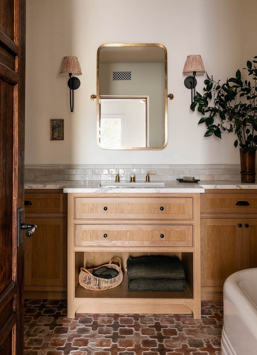 a light toned bathroom with moody lighting and decor