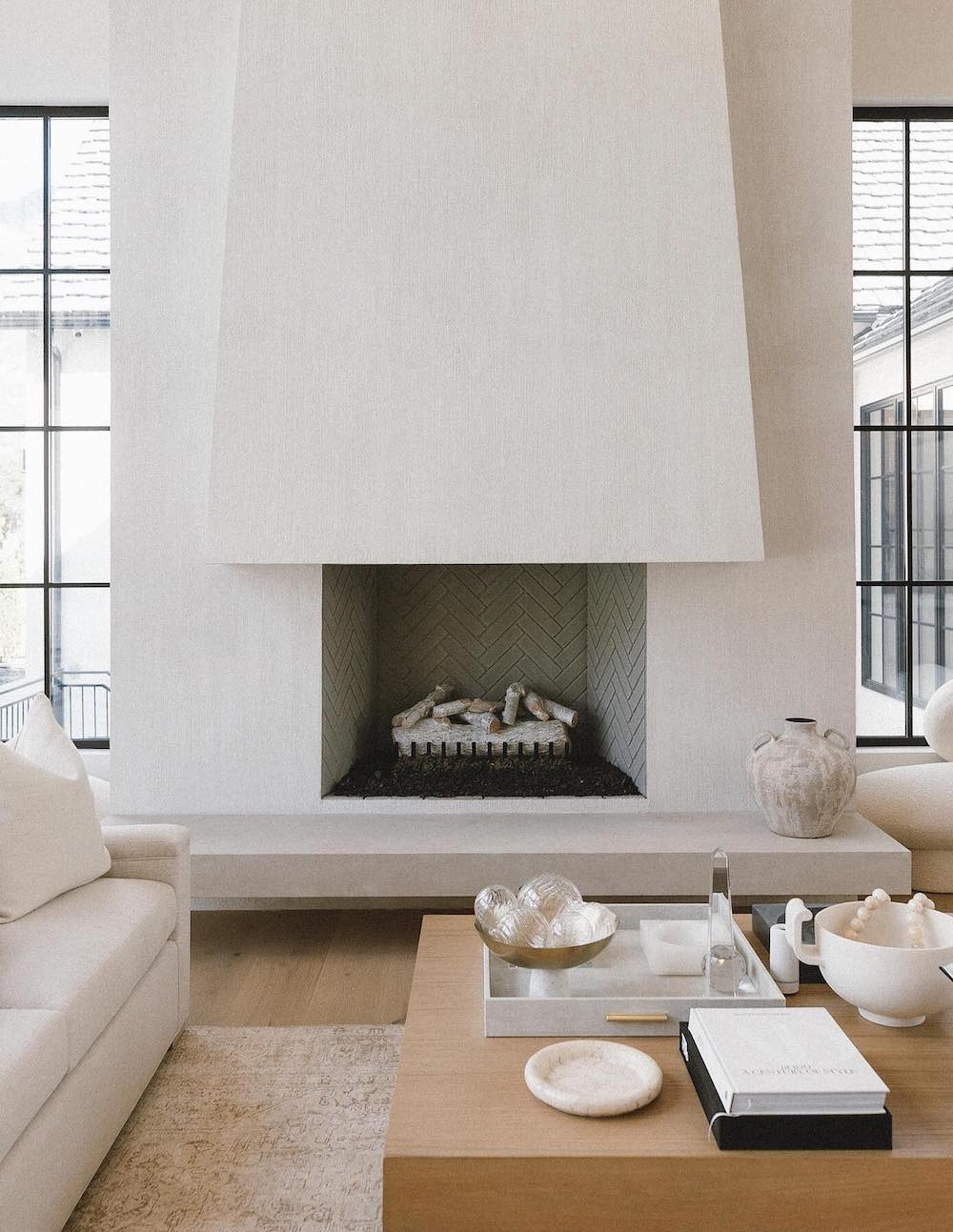 a white plaster fireplace with modern furnishings