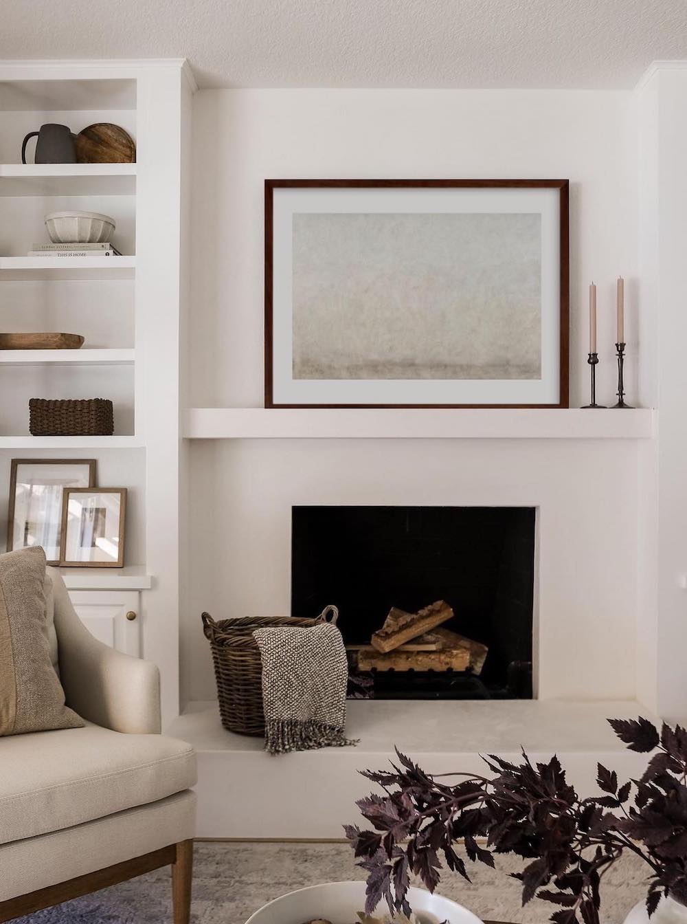 a white plaster fireplace with warm decor