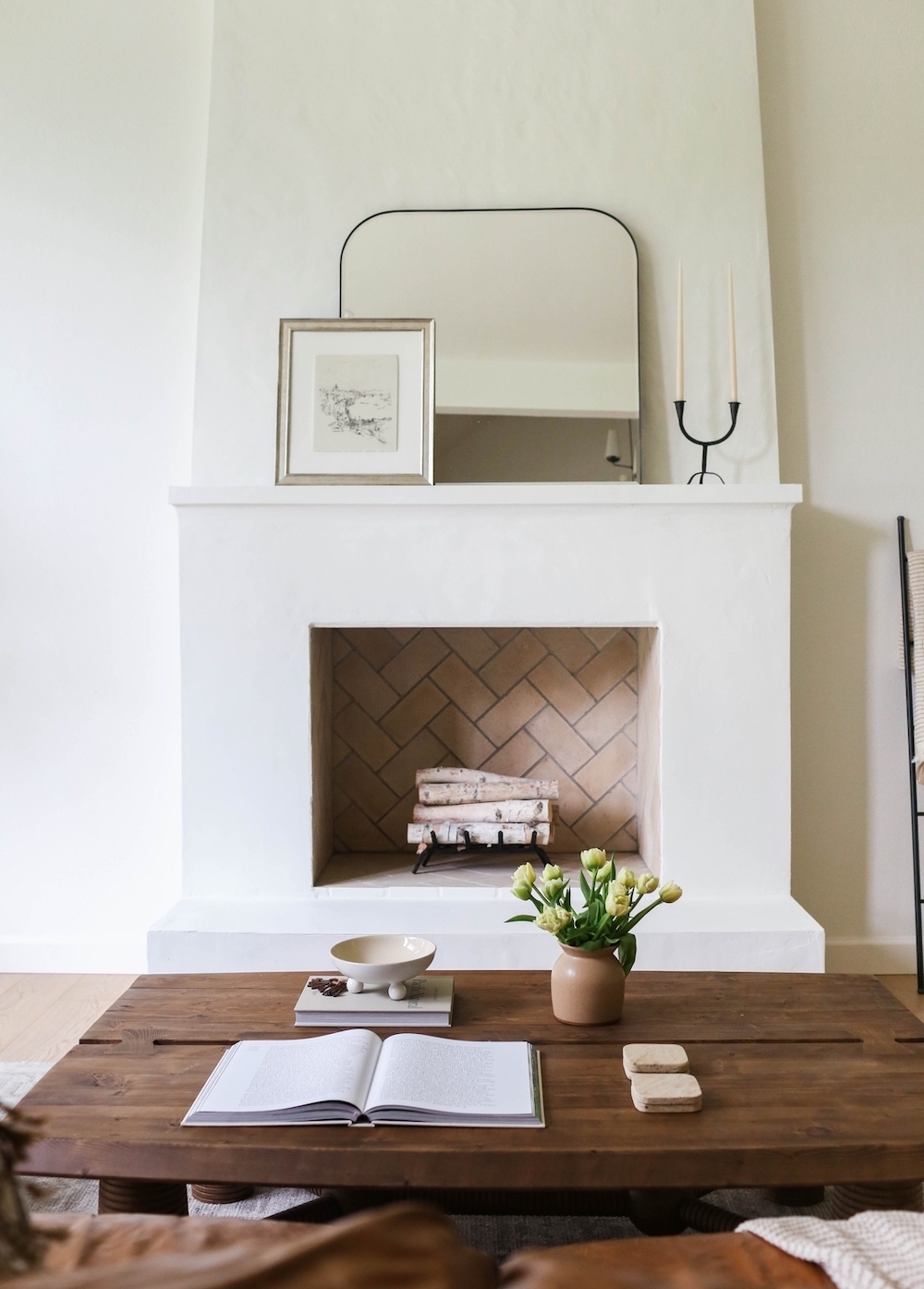 a white plaster fireplace with minimal decor