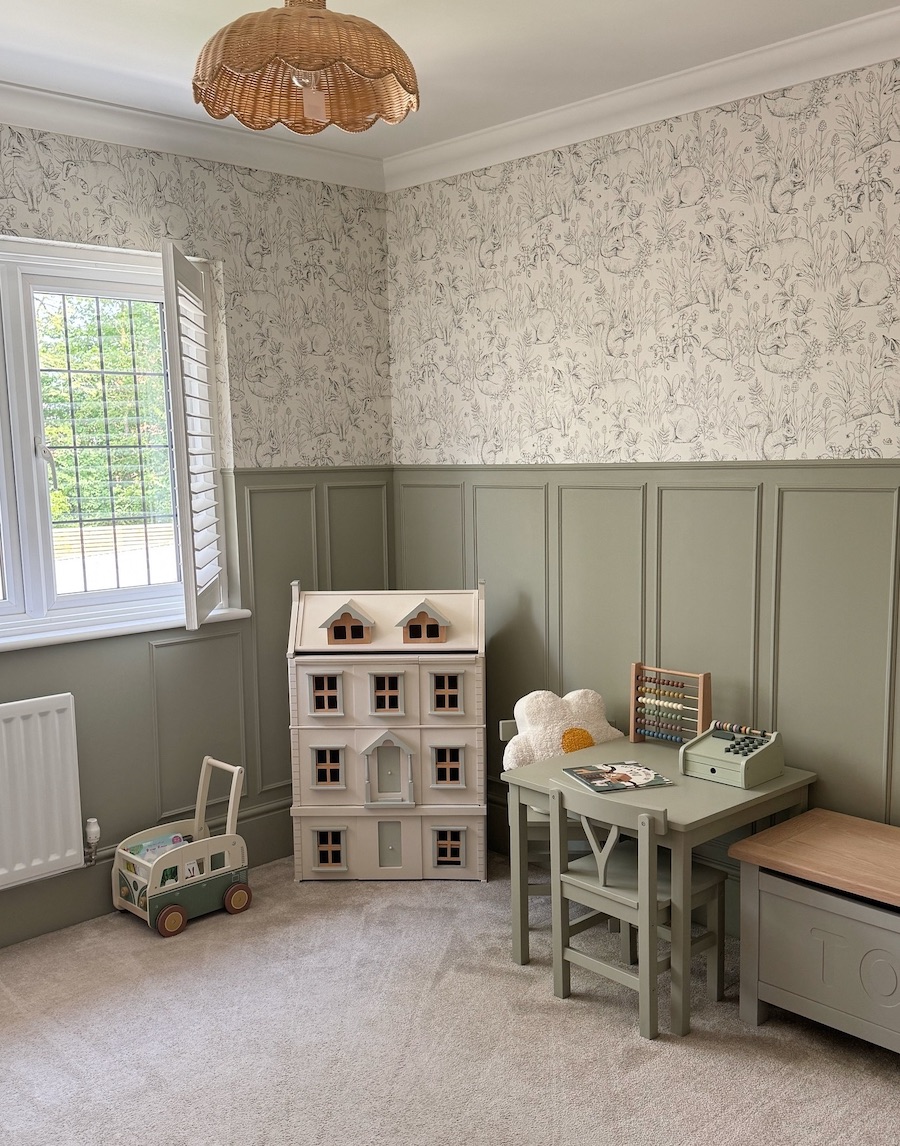 a playroom featuring green paint, wallpaper, and wooden toys