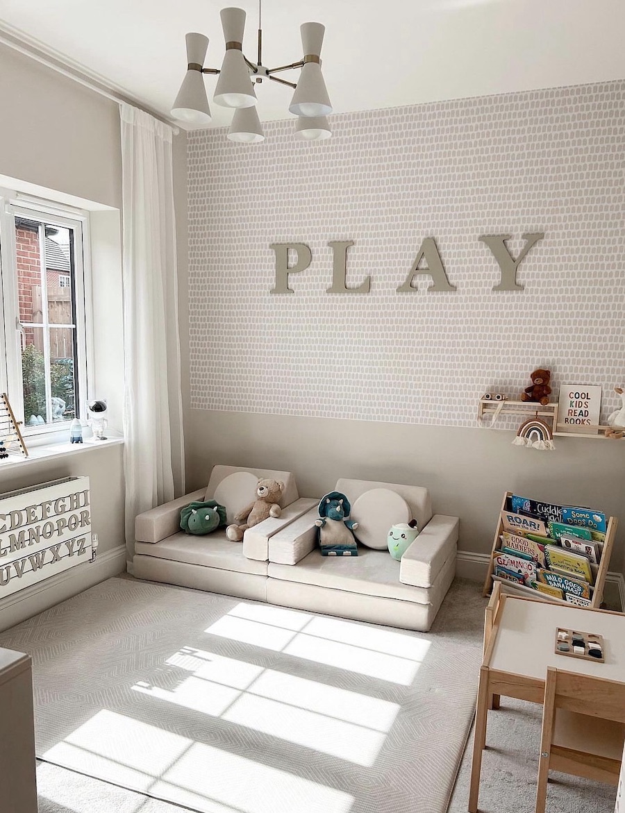 a playroom featuring soft chairs, a bookcase, and a table set