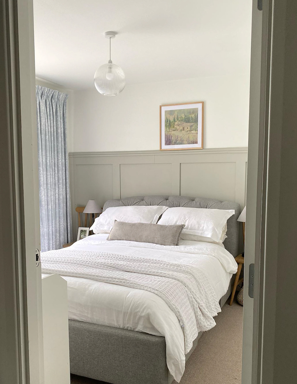 a small bedroom with grey, soft green, and ivory tones