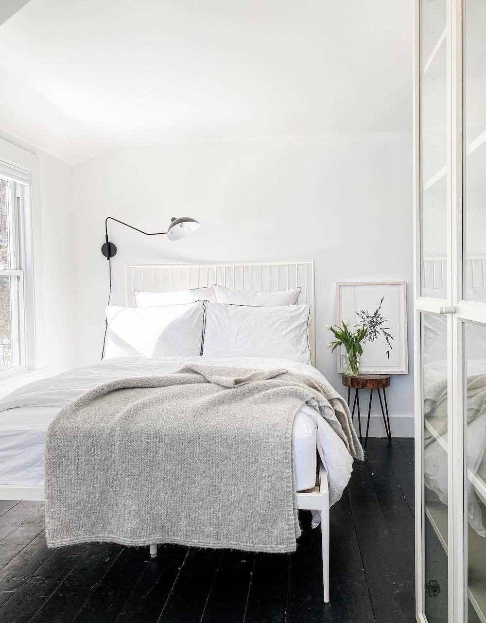 a white bedroom with modern decor and floral touches