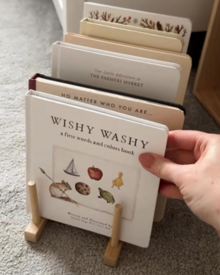 Bamboo plate rack repurposed as book display from @sophieellaandme holding board books at floor level.